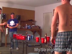 Buddies play naked beer pong in a a garage